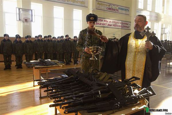 Idźcie i zabijajcie. Ofiara spełniona. – Duchowny prawosławny błogosławi karabiny otrzymane przez rekrutów w bazie wojskowej białoruskiego MSW. 